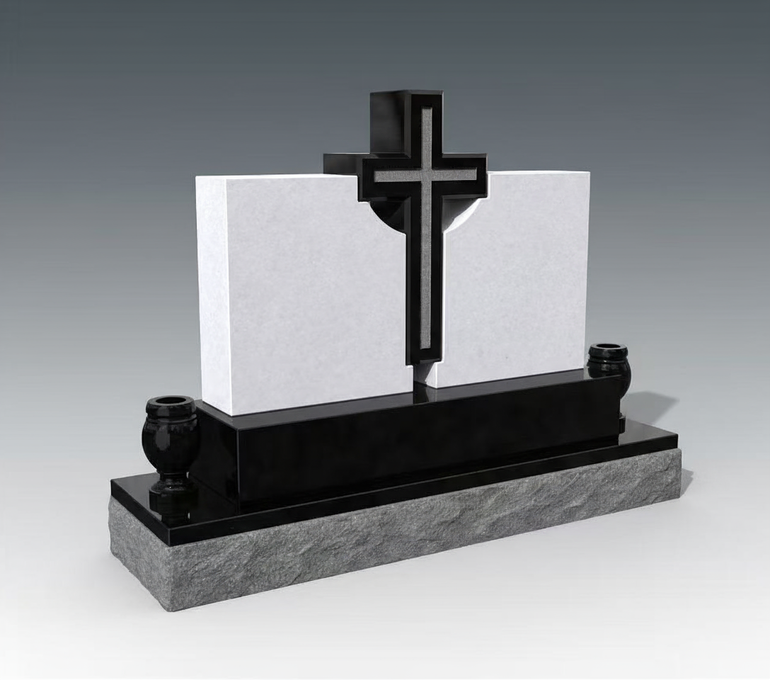 A modern Christian cross headstone featuring a prominent dark-toned cross with a lighter inlay, set between two pristine white rectangular panels. The monument sits on a dark polished base, which in turn rests on a rough-hewn grey granite foundation, flanked by two small black urns.