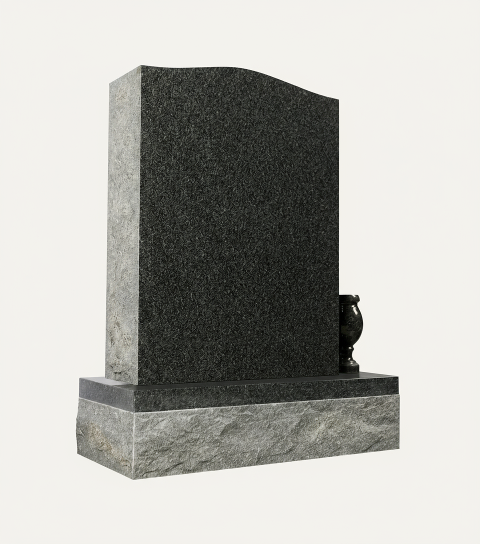A modern upright headstone crafted from dark gray speckled granite, featuring a gently curved top edge and a polished base. A small, matching granite vase sits on the right side of the base, elegantly contrasting with the rougher texture of the lower foundation.