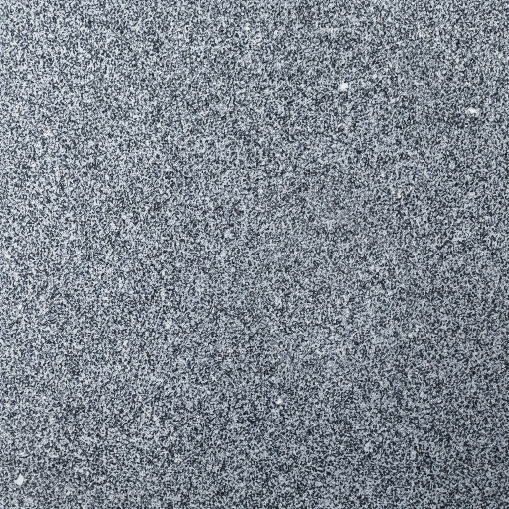 A close-up image of a speckled grey granite stone surface, showing a fine grain with irregular flecks of black, white, and various shades of grey. This robust texture is commonly used for headstones and memorials, conveying durability and a natural aesthetic.