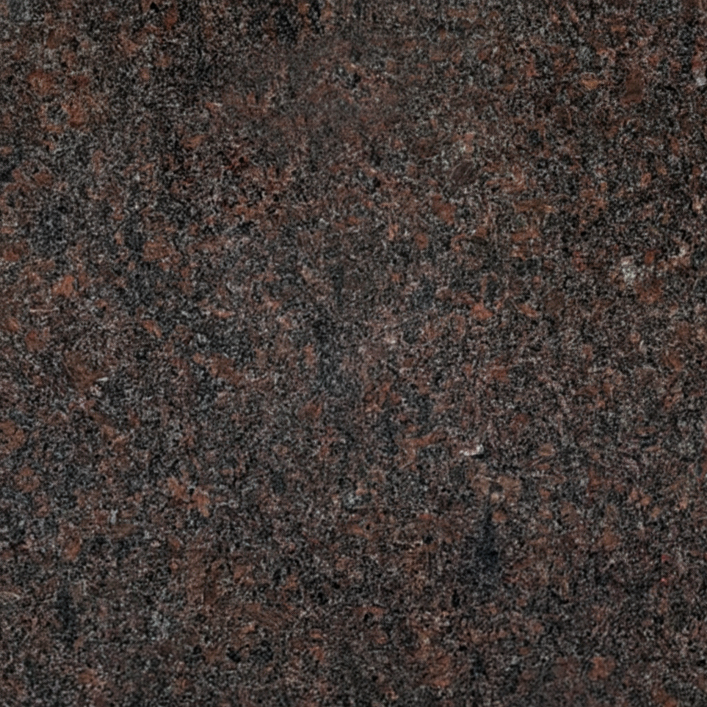 A close-up, high-resolution image of Tan Brown granite, showing its natural, speckled texture with various shades of dark brown, black, and reddish-brown. This image represents the material used for headstones and memorials.